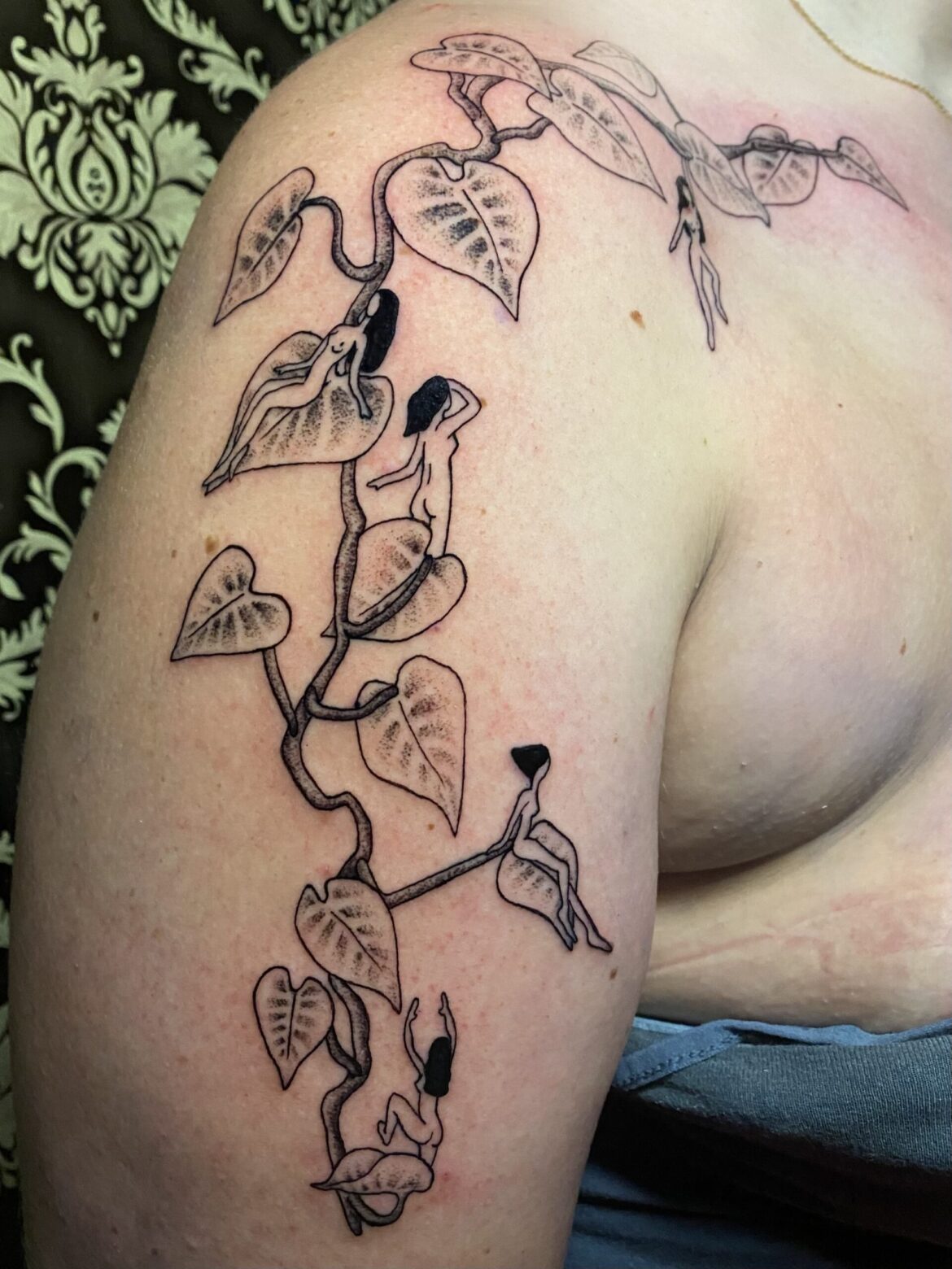 A delicate fine line tattoo of fairies climbing up a vine, going up a persons arm, by Basic Urban Witch Tattoo and Tarot in Fort Collins Colorado.